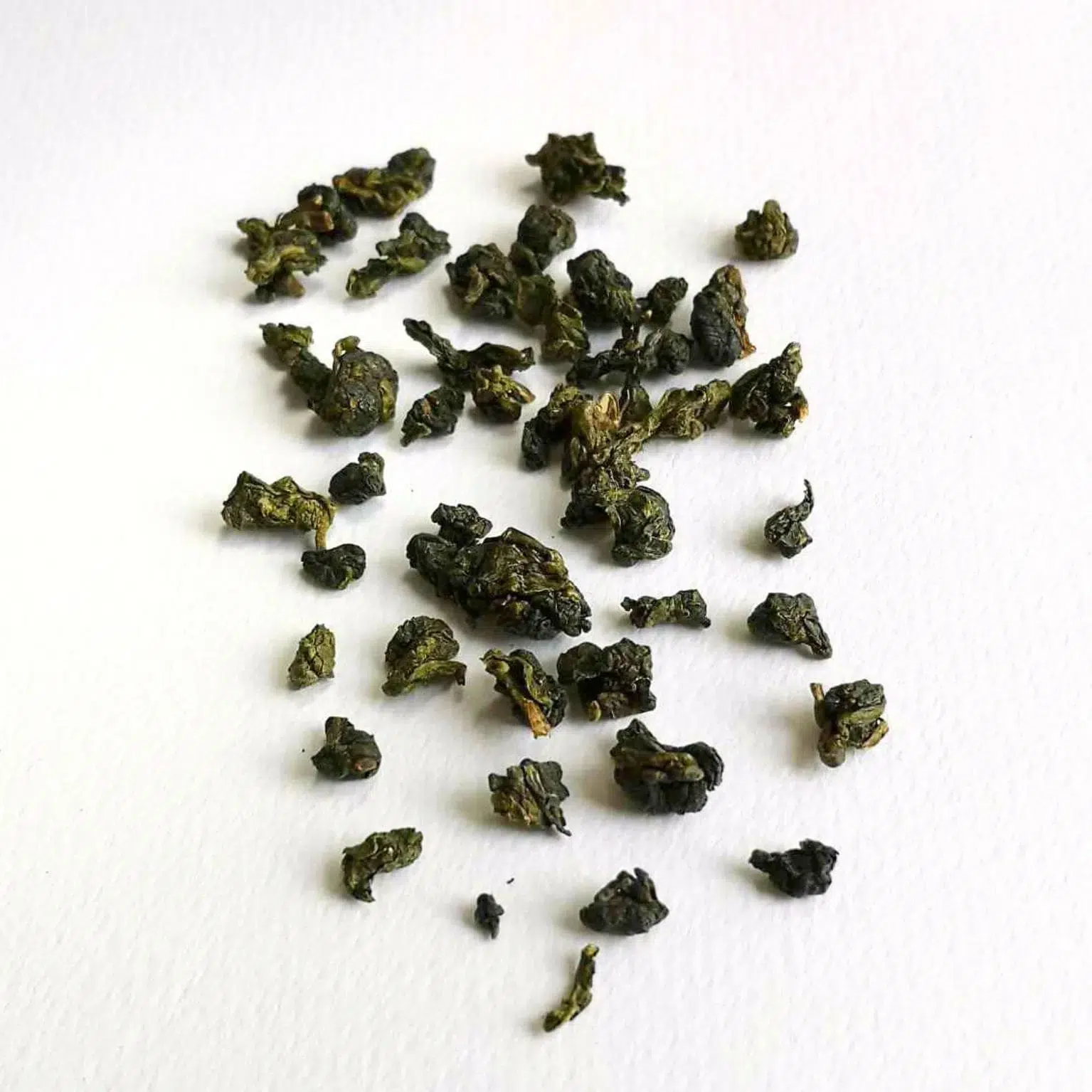 Photographie packshot des feuilles de thé en perles du Rhuanzi Wulong de Thaïlande faible oxydé