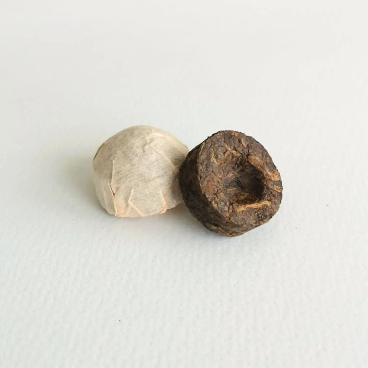 Photographie packshot sur fond blanc de deux thés Minis TUOCHA 2015 en Puer Shu (cuit)